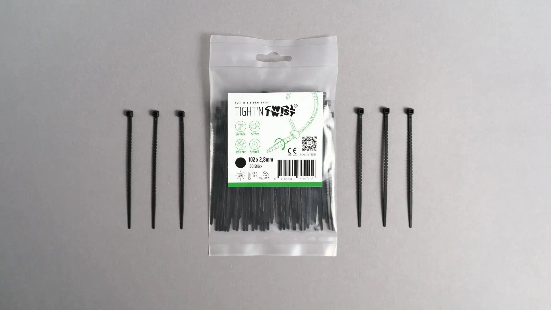 Ein Tight'n Twist Kabelbinder 102x2p8 mm in Schwarz liegt neben der Originalverpackung – Detailansicht des innovativen Designs