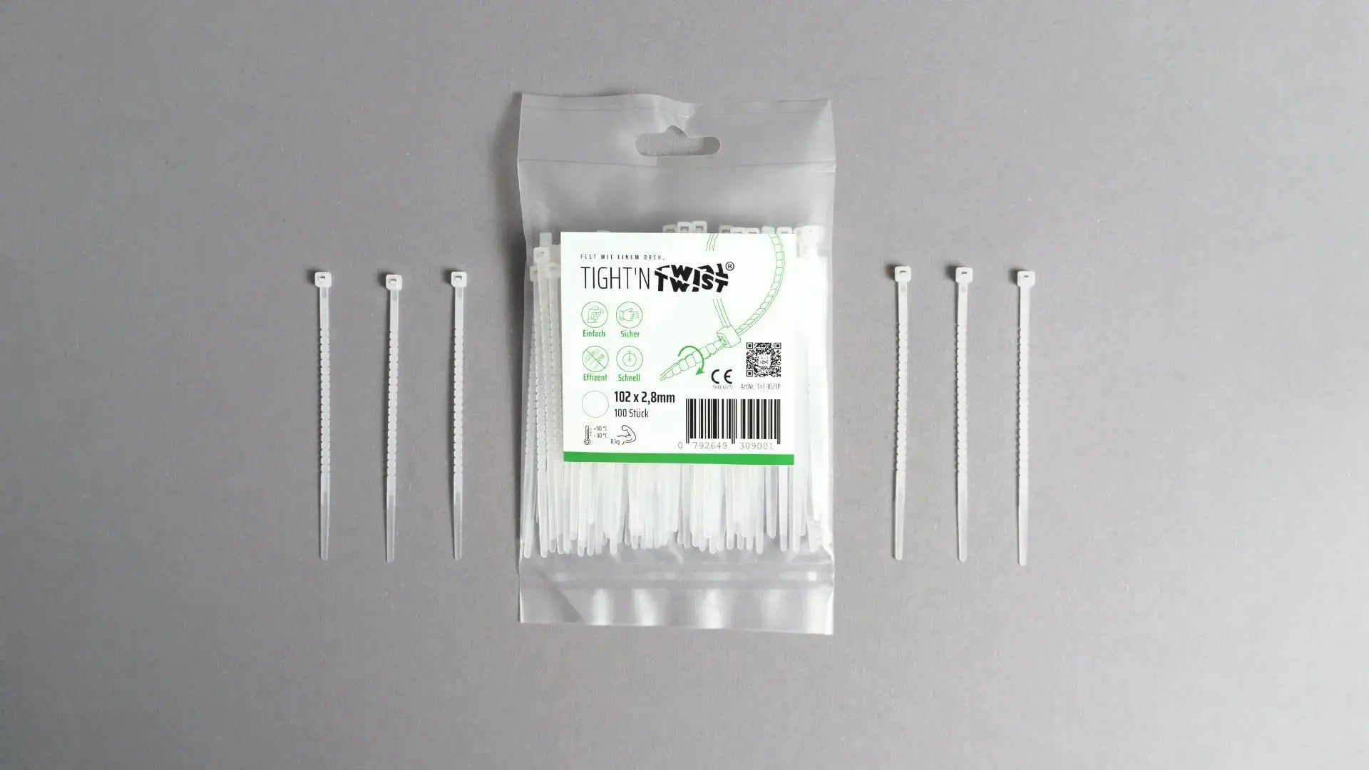 Ein Tight'n Twist Kabelbinder 102x2p8 mm in Weißliegt neben der Originalverpackung – Detailansicht des innovativen Designs